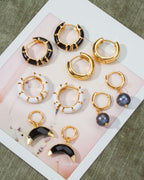 Collection of Jump Through Hoops Interchangeable Earrings, with Onyx, plain gold hoops, and enamel.