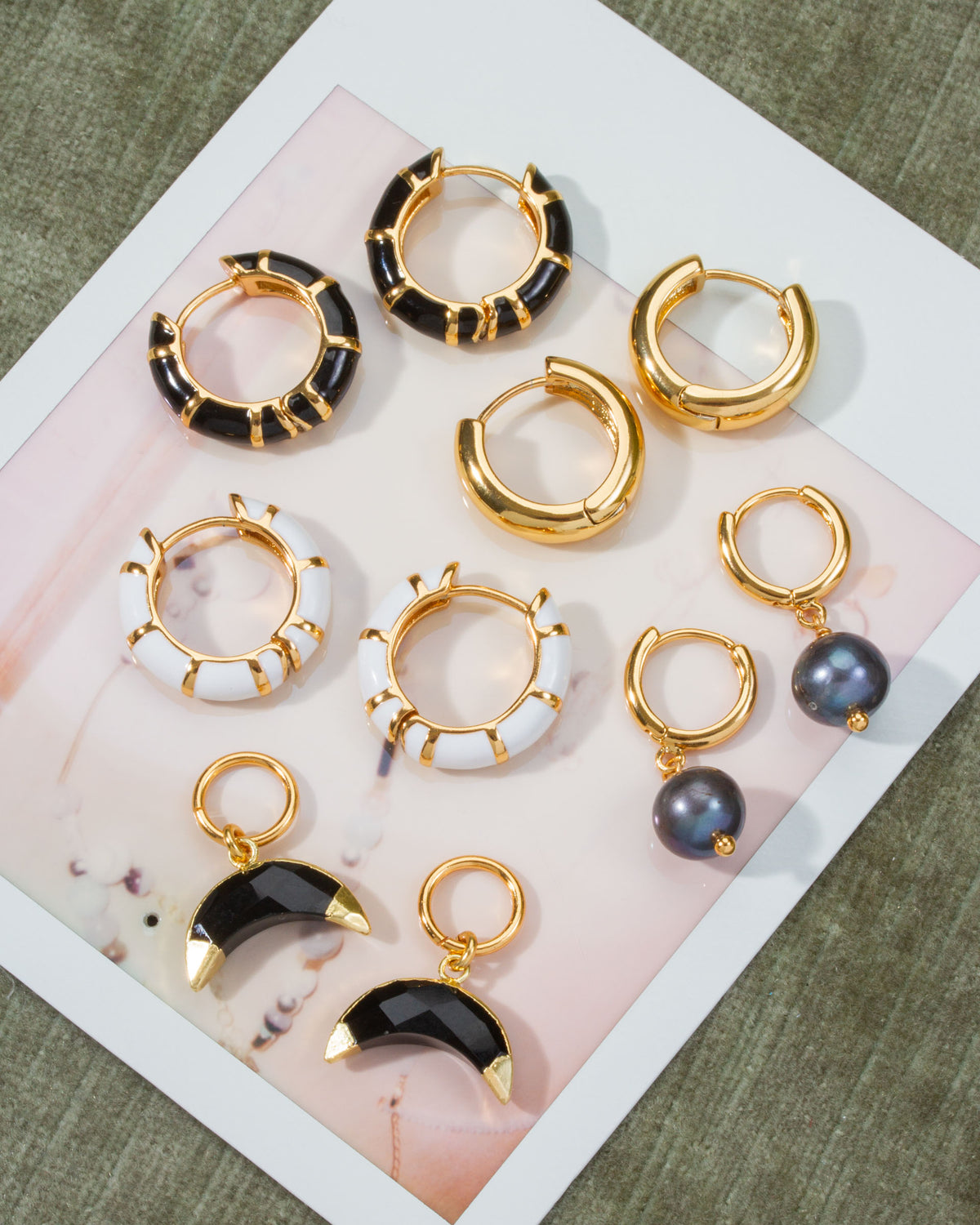 Collection of Jump Through Hoops Interchangeable Earrings, with Onyx, plain gold hoops, and enamel.