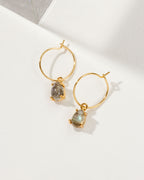 Two gold Airy Hoop Earrings with Labradorite gemstones are displayed on a white surface.