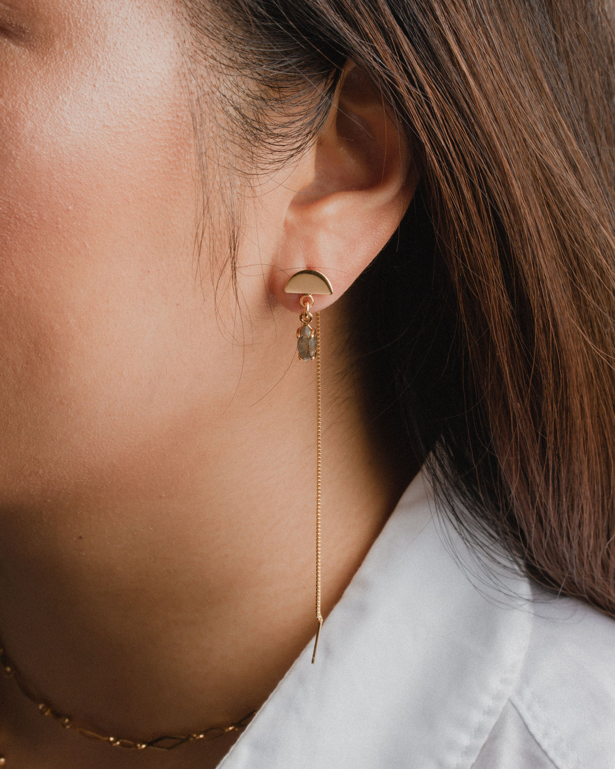 Ethereal Post Threader Earring is gold with a gray gemstone and cascading chain.