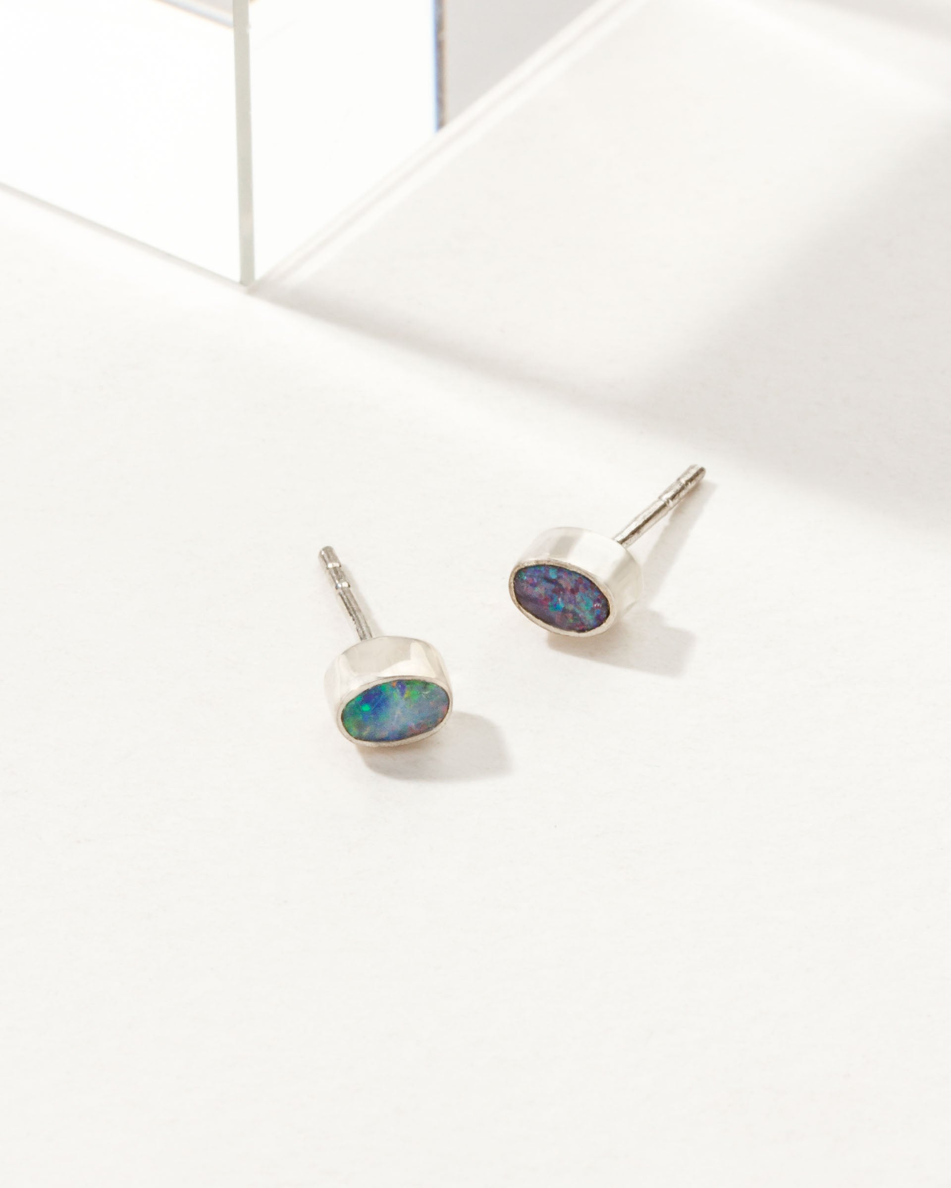 Oval Blue Wave Opal earrings with a sterling silver bezel.