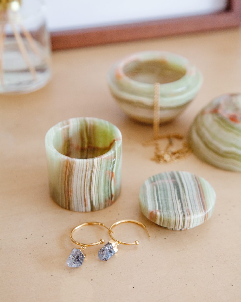 Green calcite jewelry box with a gold necklace and earrings.