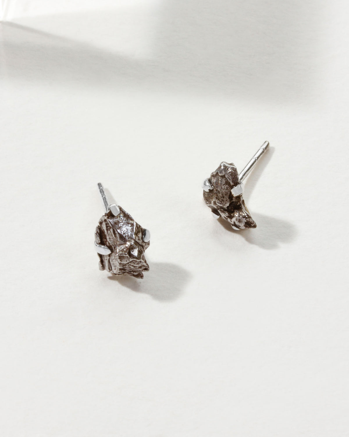Two Meteorite Sterling Silver Post earrings on a white surface.