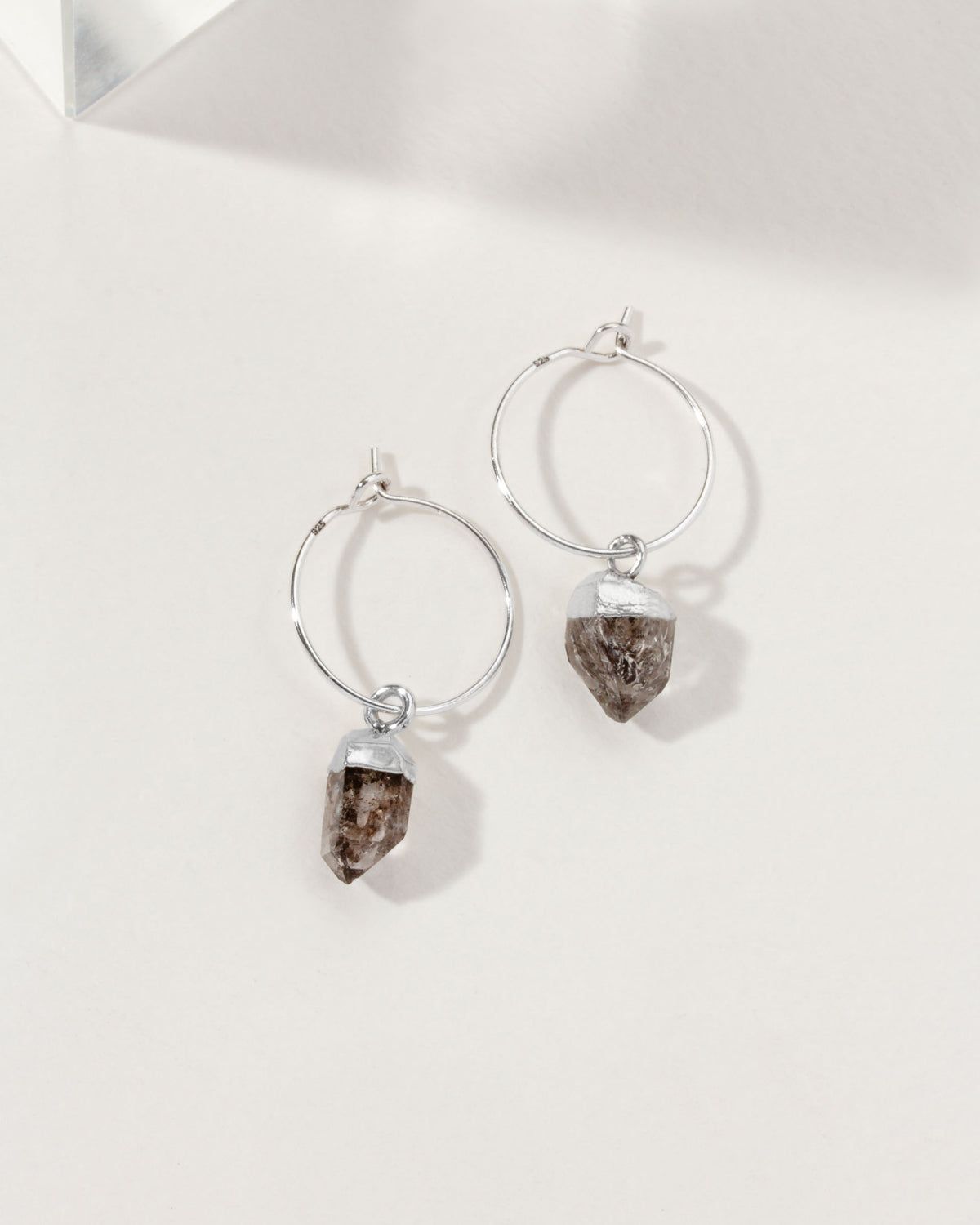 Sterling silver mini hoop earrings with a raw Herkimer Quartz "diamond" charm.