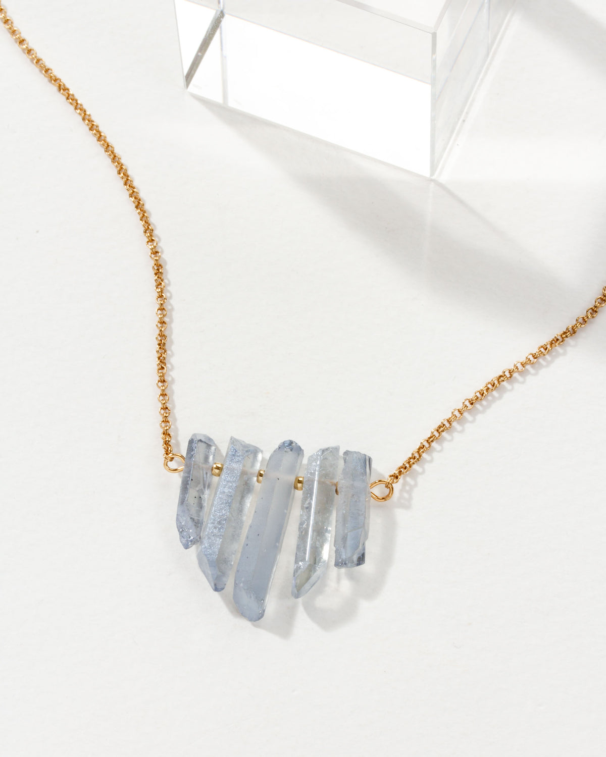 Rainy Day necklace in Ice Blue with a gold chain.