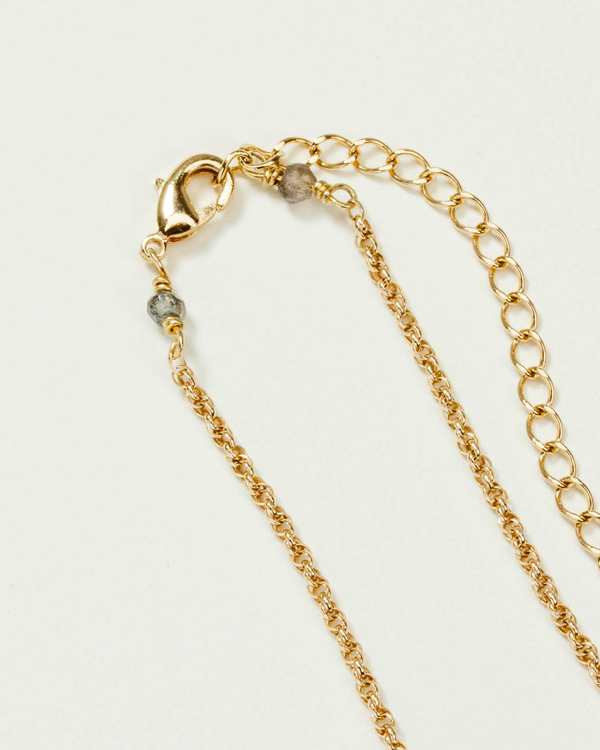 Golden chain with a clasp and a beaded section of the Terrarium Medallion Necklace.