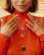 Moss Agate medallion necklace with a gold chain, styled with other gemstone pendants.
