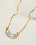 Eclipse necklace with a gold chain and a moonstone crescent shaped pendant.