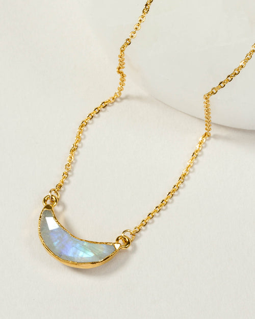 Eclipse necklace with a gold chain and a moonstone crescent shaped pendant.
