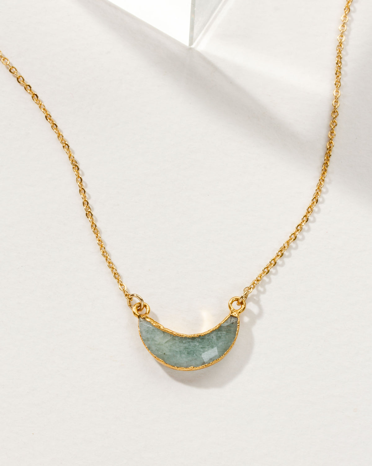 Eclipse Necklace with an Aquamarine crescent moon pendant and gold chain.