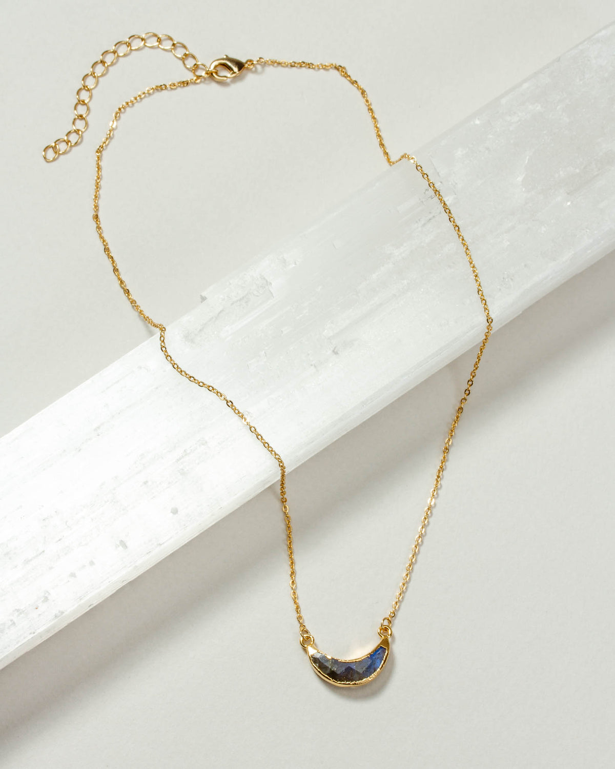 Gold chain necklace featuring a Labradorite gemstone crescent moon pendant.