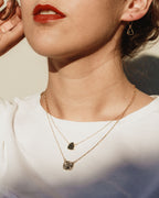 Model wearing Spellbound necklace with black druzy and marbled white stone and black earrings