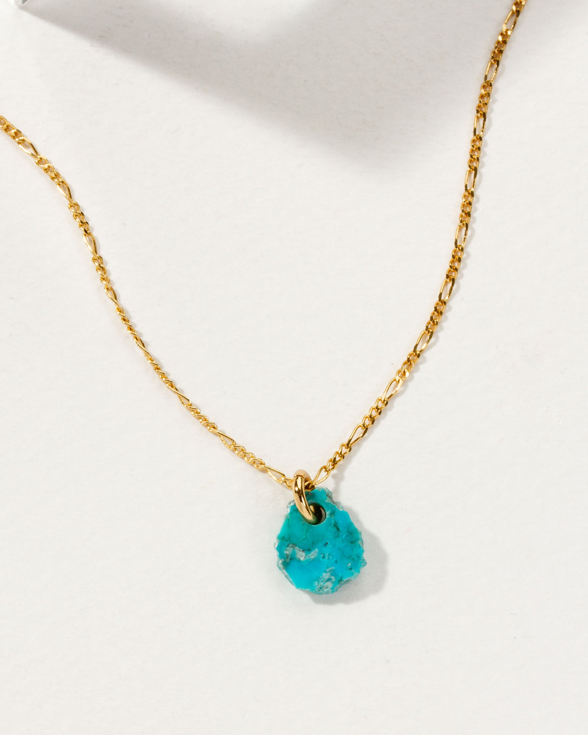 Flower Petal Necklace with a turquoise gemstone charm and gold chain.