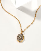 Gold chain necklace with oval tourmalinated quartz pendant.