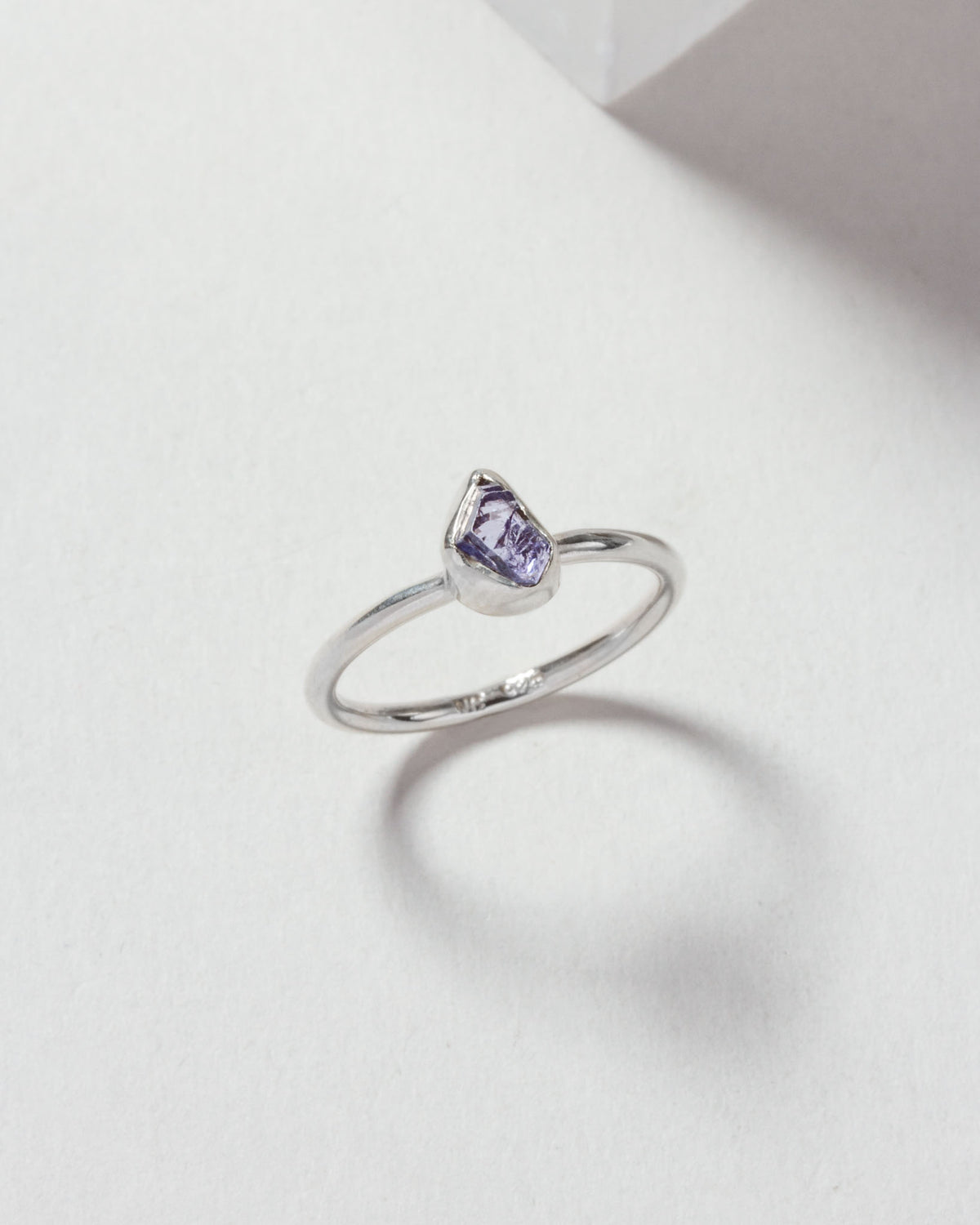 Silver ring featuring a tanzanite gemstone on a white surface.