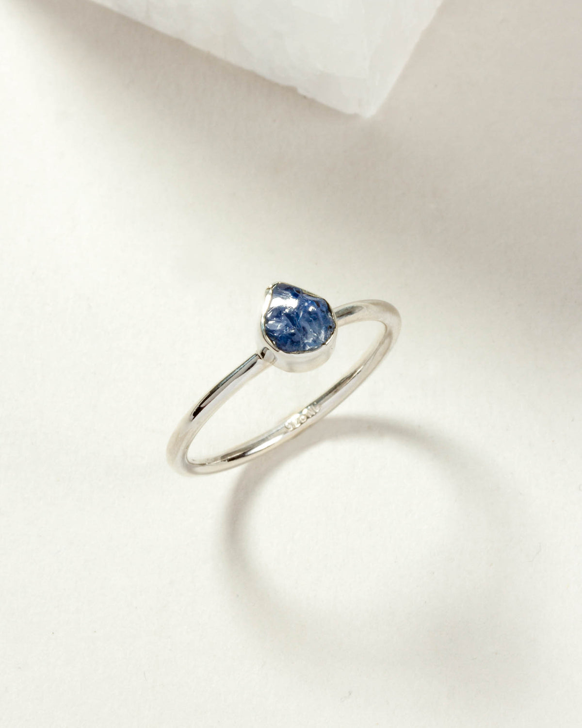 Sterling silver ring with a raw-cut blue sapphire gemstone.
