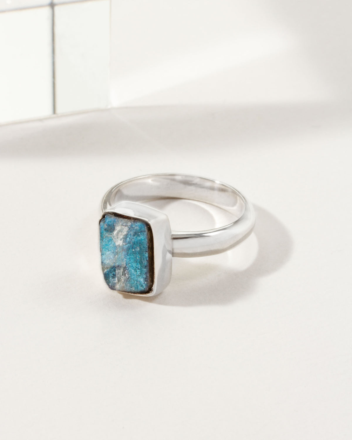 Silver ring featuring a square, blue labradorite stone.
