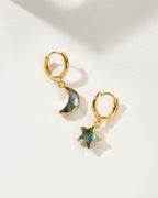 Pair of mismatched gold huggie hoop earrings with labradorite star and moon charms