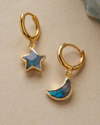 Pair of mismatched gold huggie hoop earrings with labradorite star and moon charms