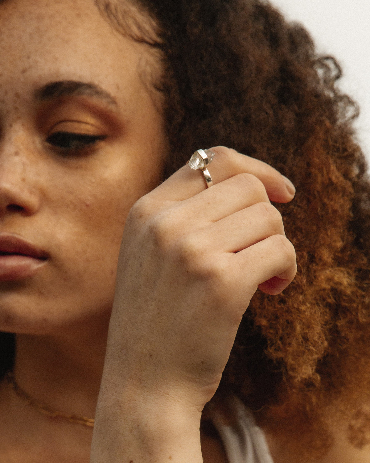 A Sterling Silver ring with a clear Herkimer Quartz stone on a model's finger.