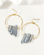 Ice blue colored quartz hoop earrings on a white table