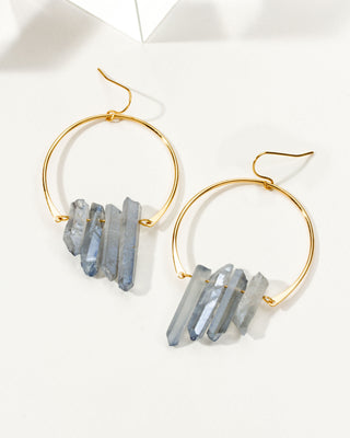 Ice blue colored quartz hoop earrings on a white table