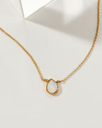 Necklace with a teardrop-shaped moonstone pendant and 14k gold plated brass chain.