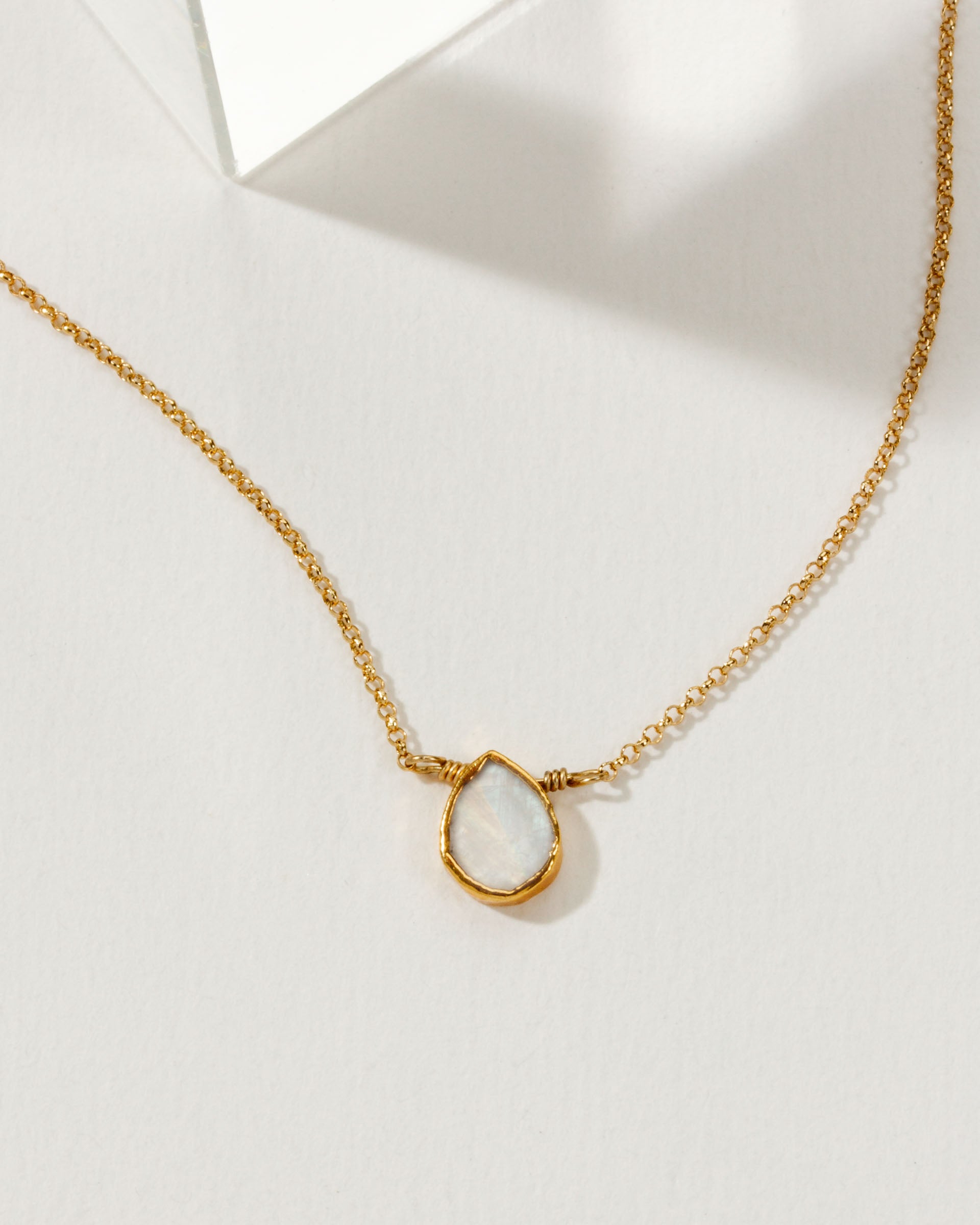 Necklace with a teardrop-shaped moonstone pendant and 14k gold plated brass chain.