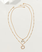 Gold necklace set with a moonstone crescent moon and a sunburst pendant.