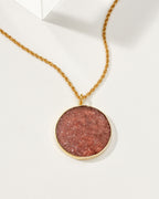 Gold chain necklace featuring a strawberry quartz medallion.