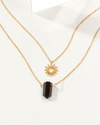 Sun Salutation necklace set with an onyx charm and a sun charm on gold chain.