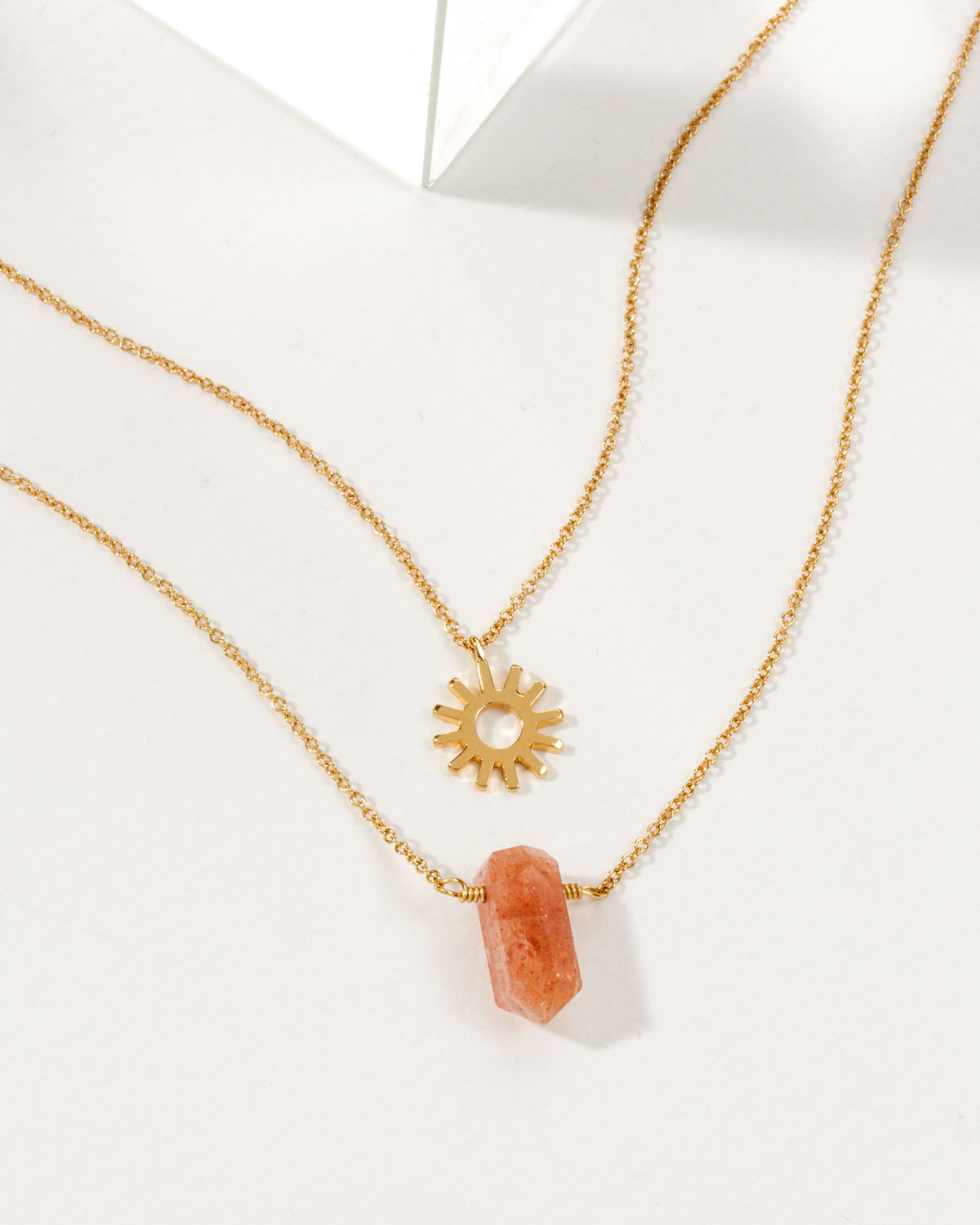 Sun Salutation Necklace Set with a sun charm and a Sunstone gemstone on gold chains.