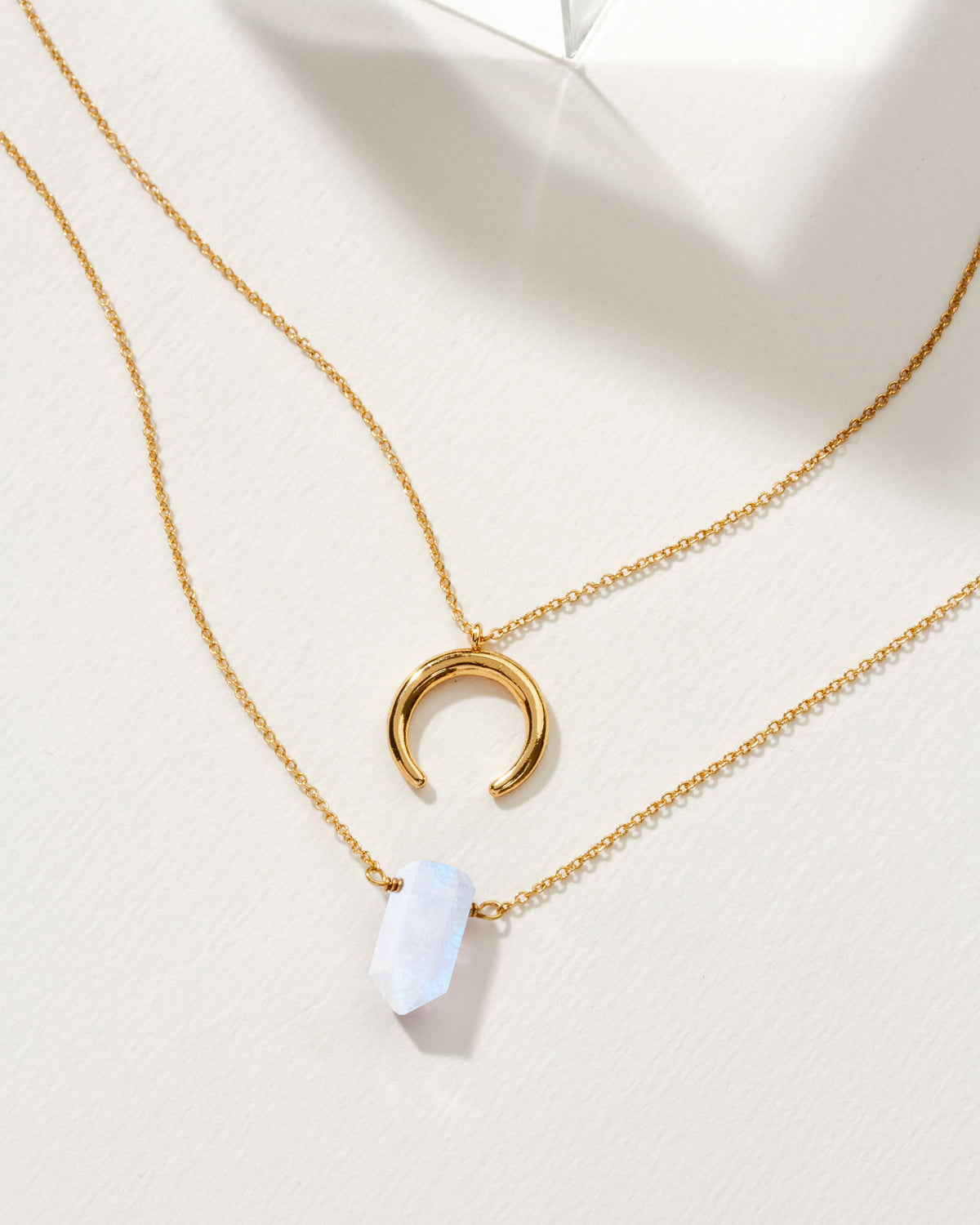Gold layered necklace set with moonstone point and crescent moon pendants.