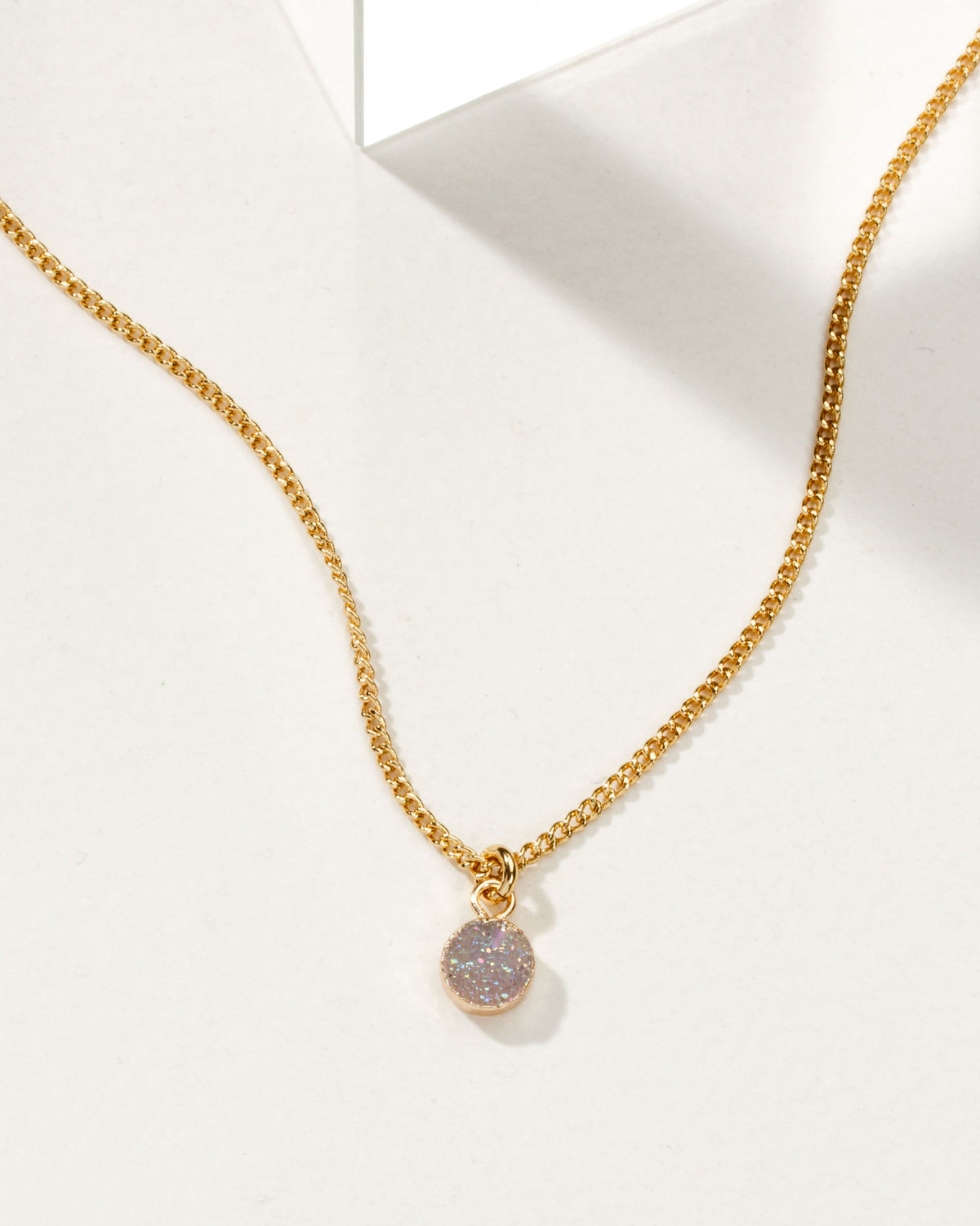 Gold chain necklace with a sparkly purple druzy charm.