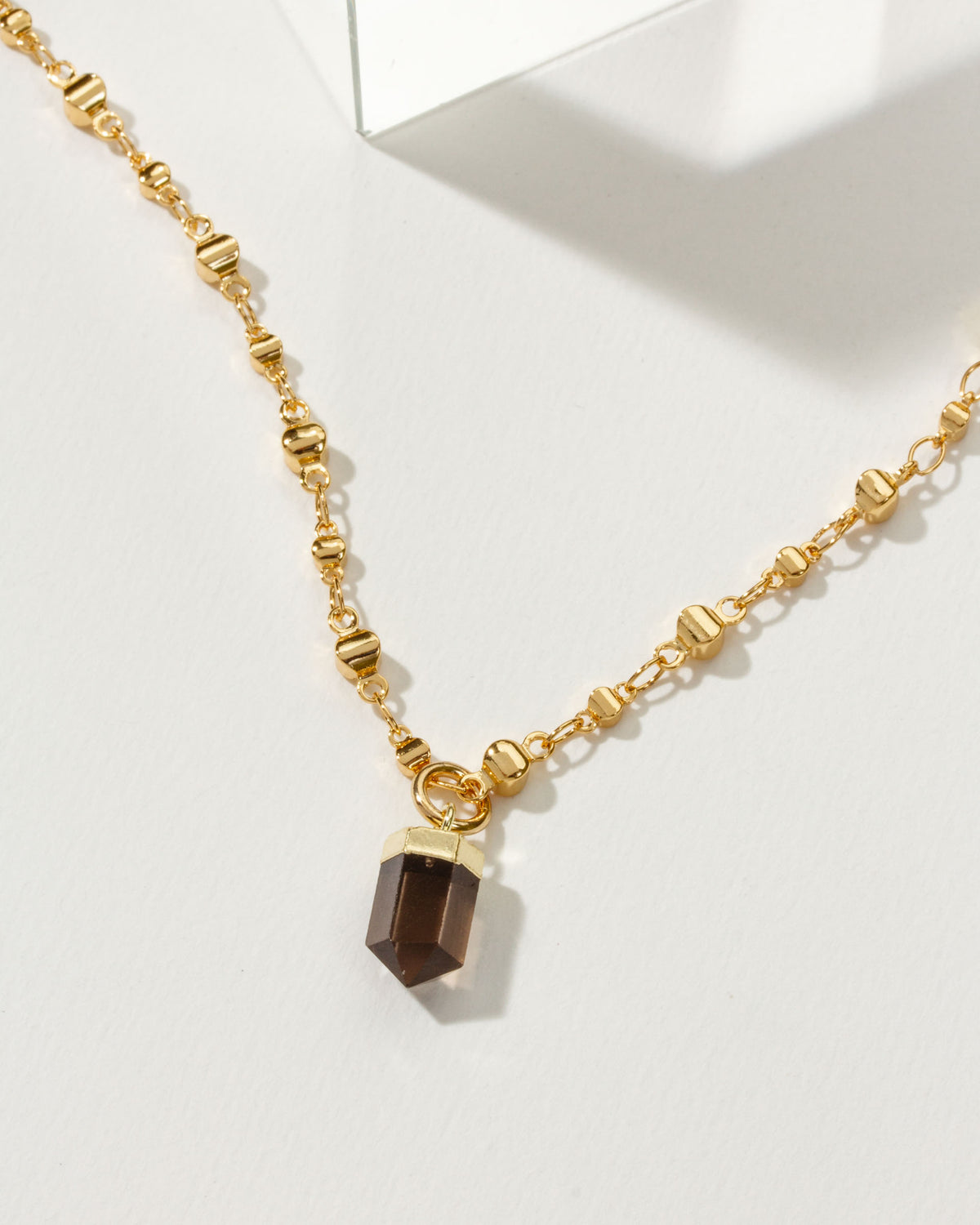 Gold beaded chain necklace with a Smoky Quartz crystal pendant.
