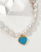 Necklace featuring baroque pearls and a turquoise heart pendant.