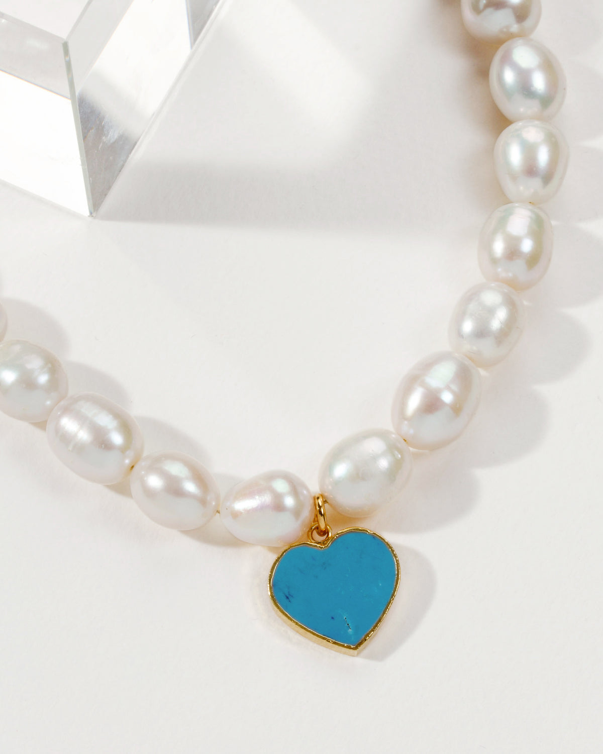 Necklace featuring baroque pearls and a turquoise heart pendant.