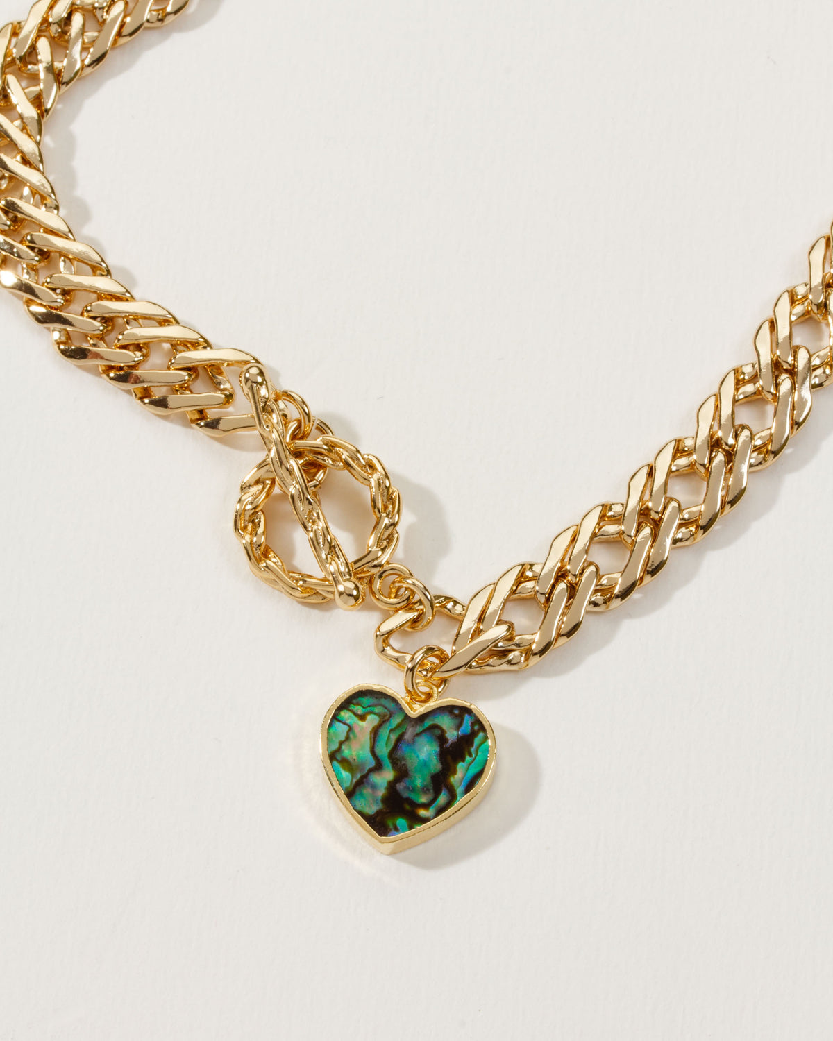 Gold chain toggle necklace with an abalone heart pendant.