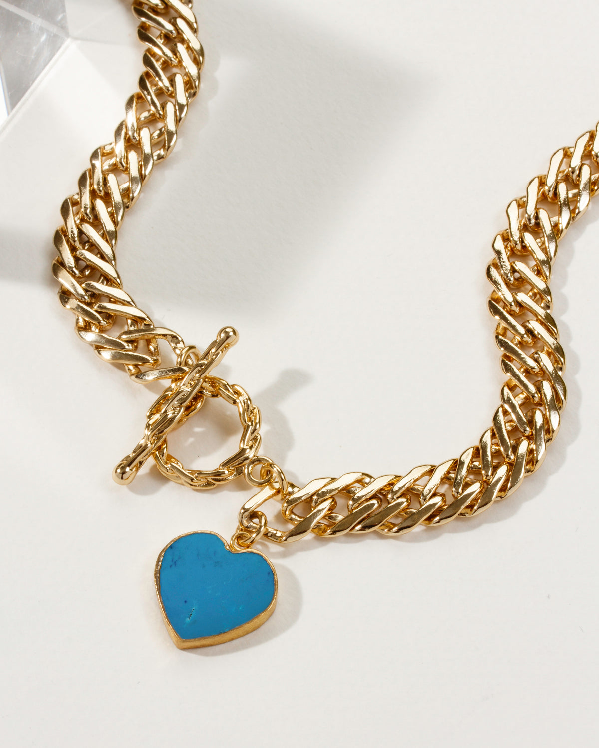 Gold chain necklace with a turquoise howlite heart-shaped pendant.