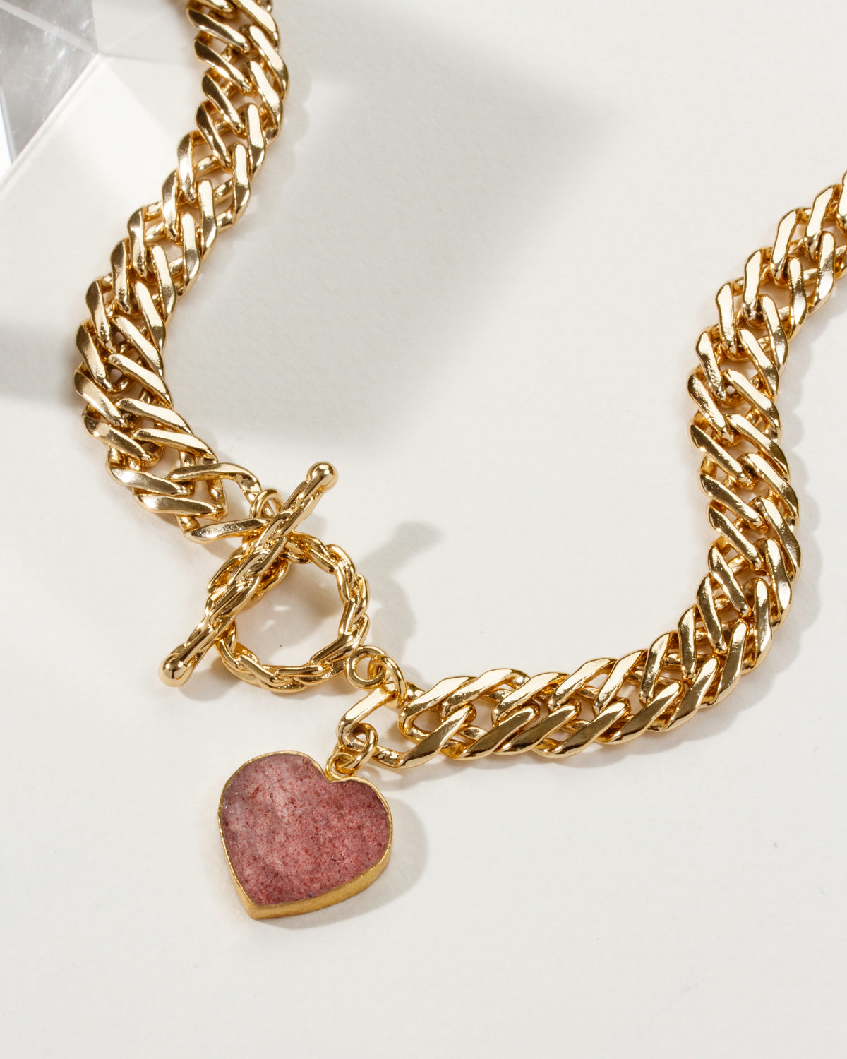 Gold chain necklace with toggle clasp and strawberry quartz heart pendant.