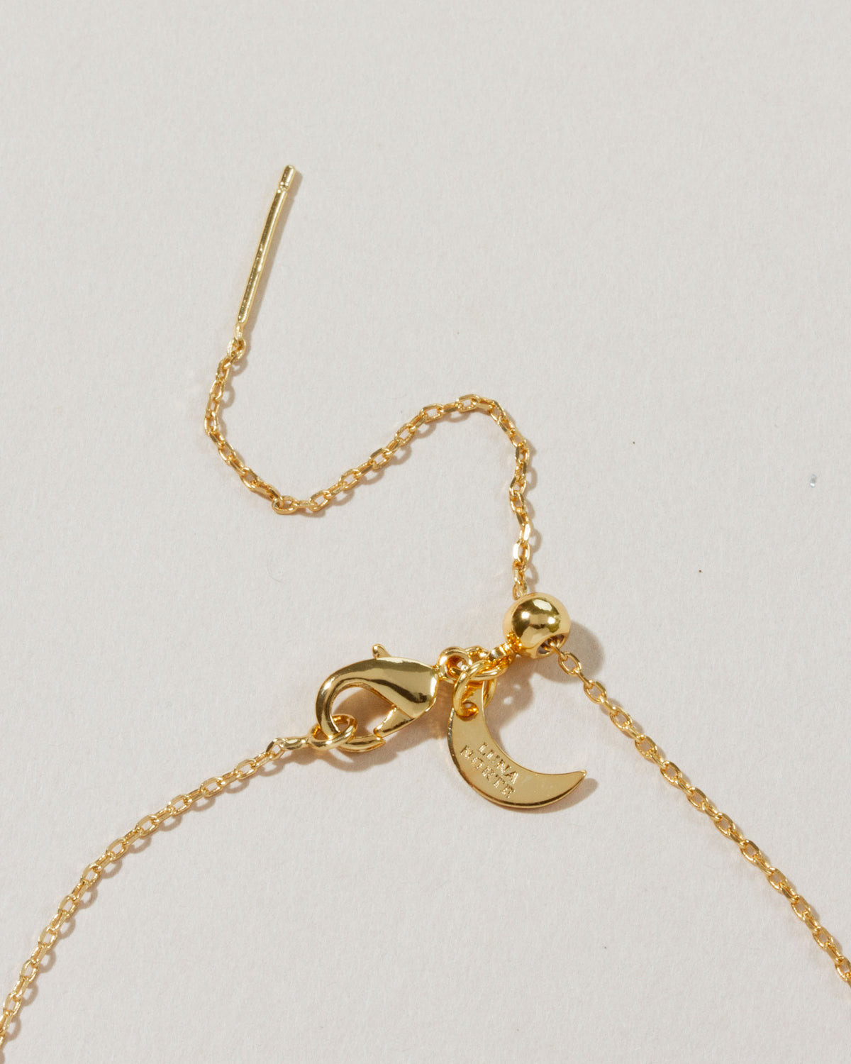 Close-up of the Celestial Being necklace clasp and adjustable chain, with tiny crescent moon detail.