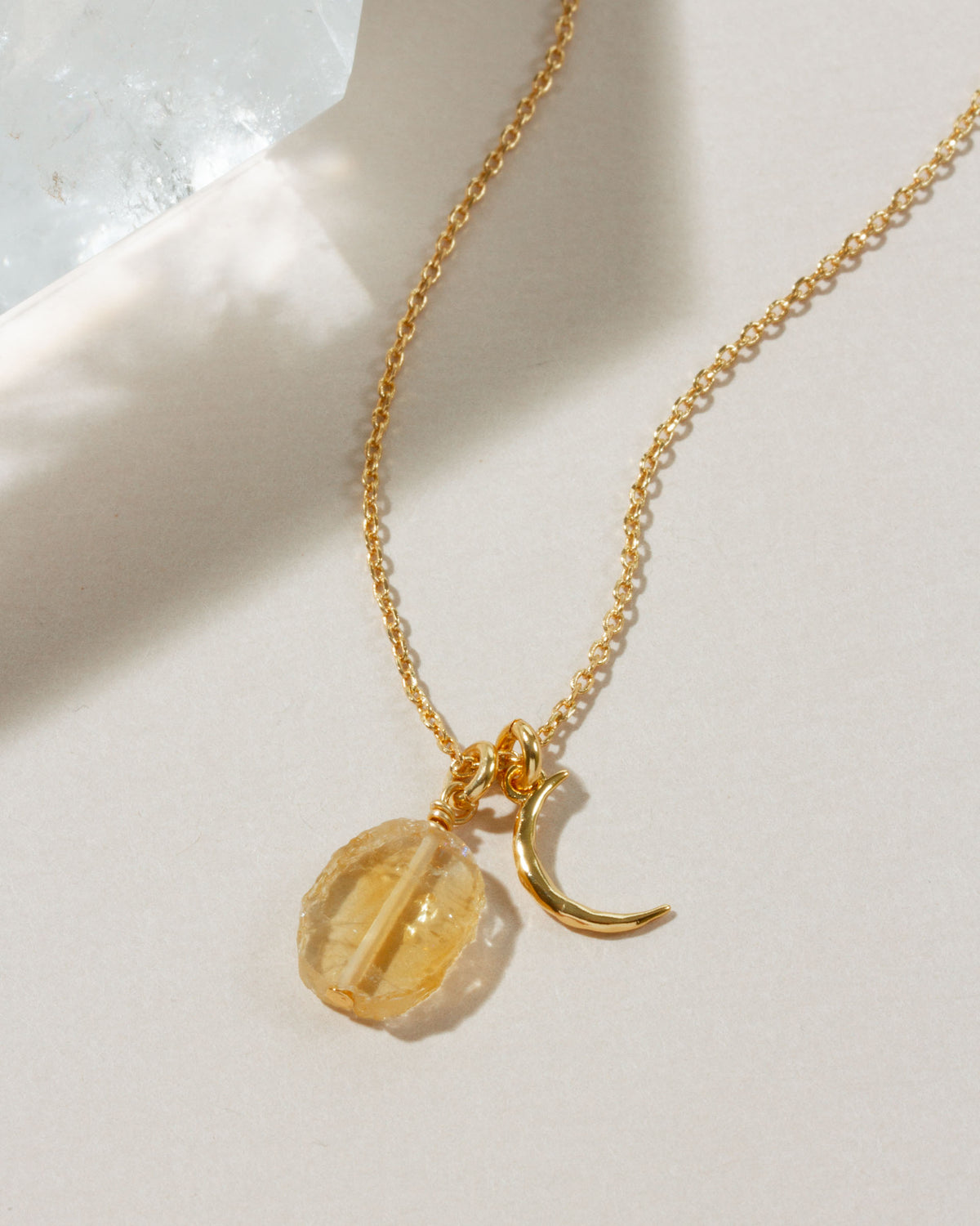Gold necklace with a crescent moon charm and Citrine gemstone.