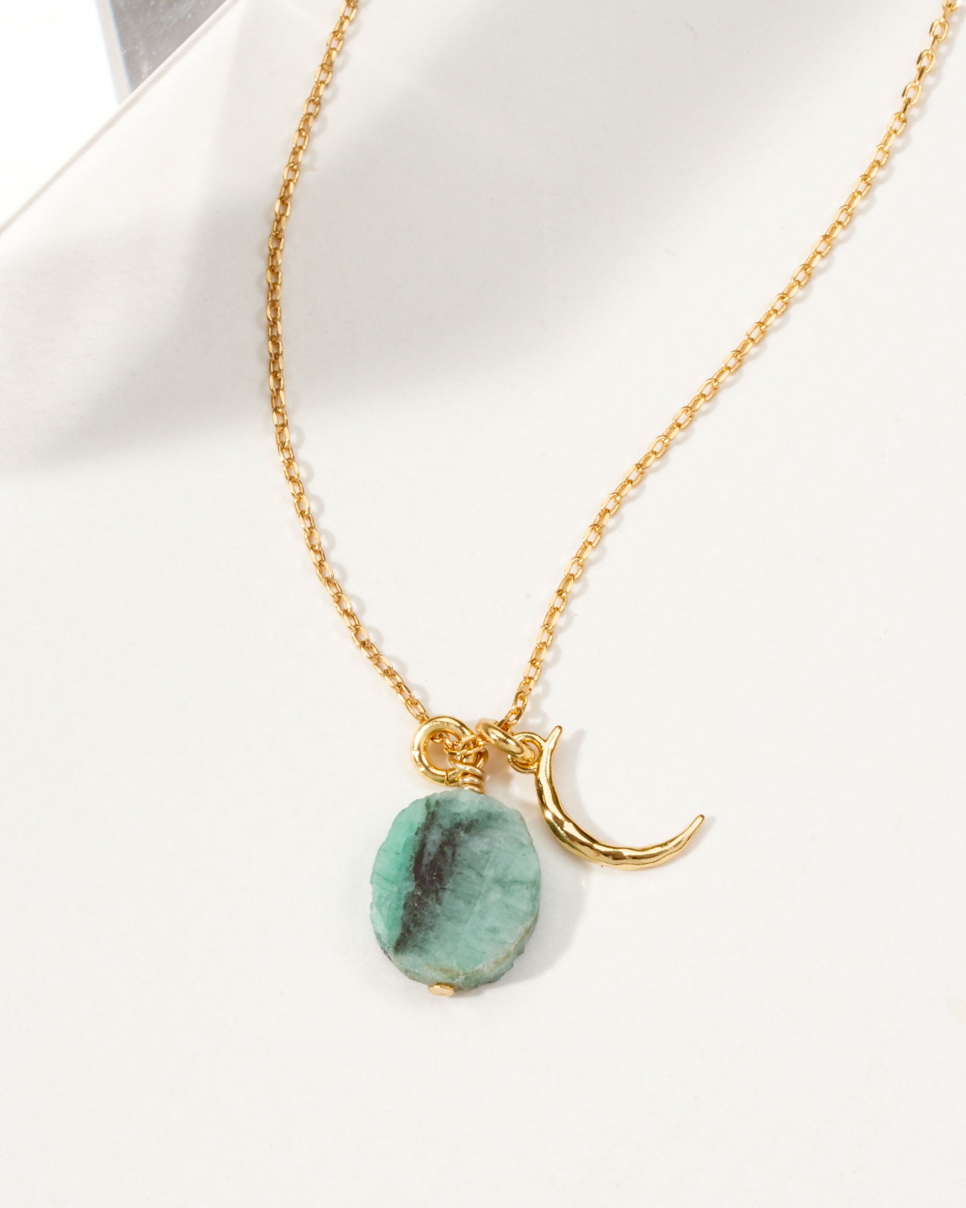 Gold chain necklace with crescent moon charm and green Emerald gemstone.