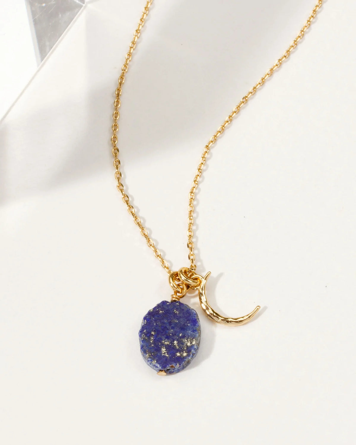 Gold necklace with crescent moon charm and Lapis Lazuli gemstone.