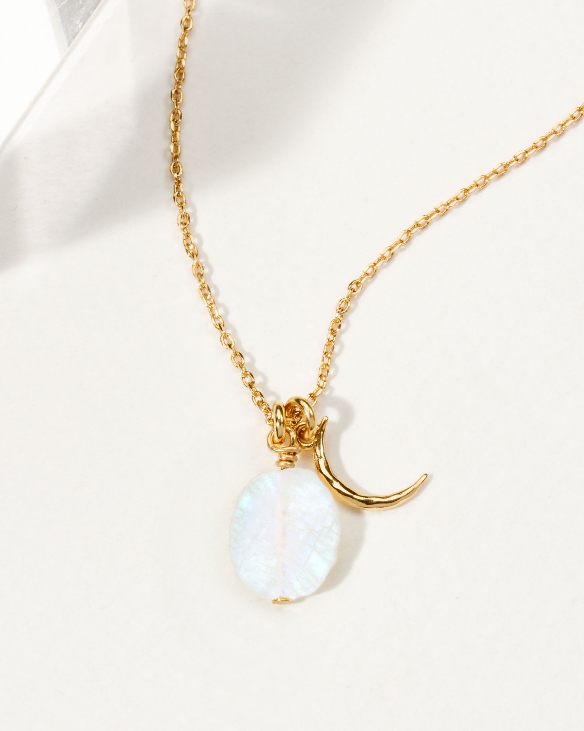 Gold necklace featuring a crescent moon charm and a Moonstone gemstone.