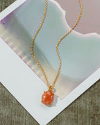 Gold chain necklace with a Sunstone pendant.