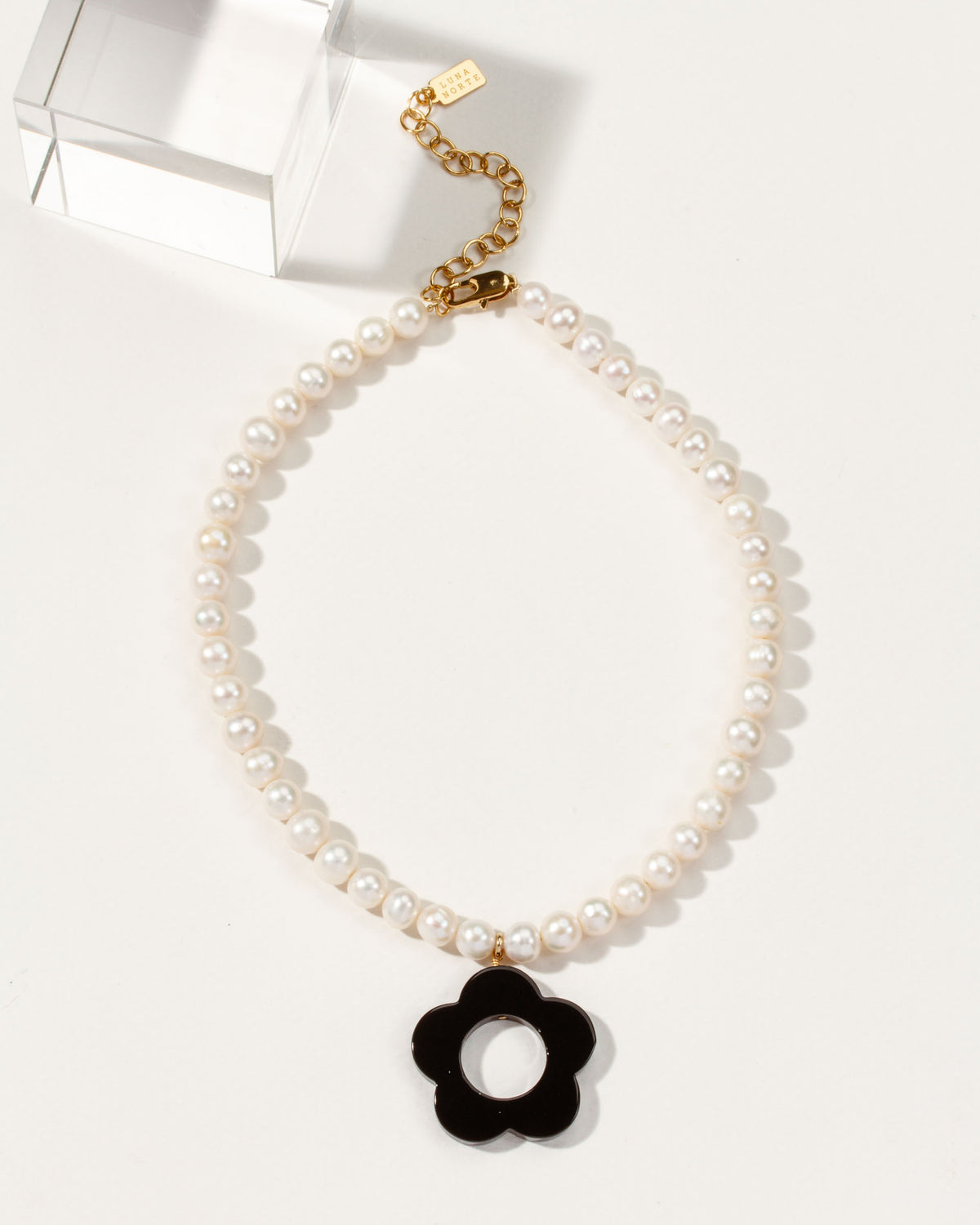 Oops-A-Daisy necklace with pearl beads and an Onyx flower pendant.