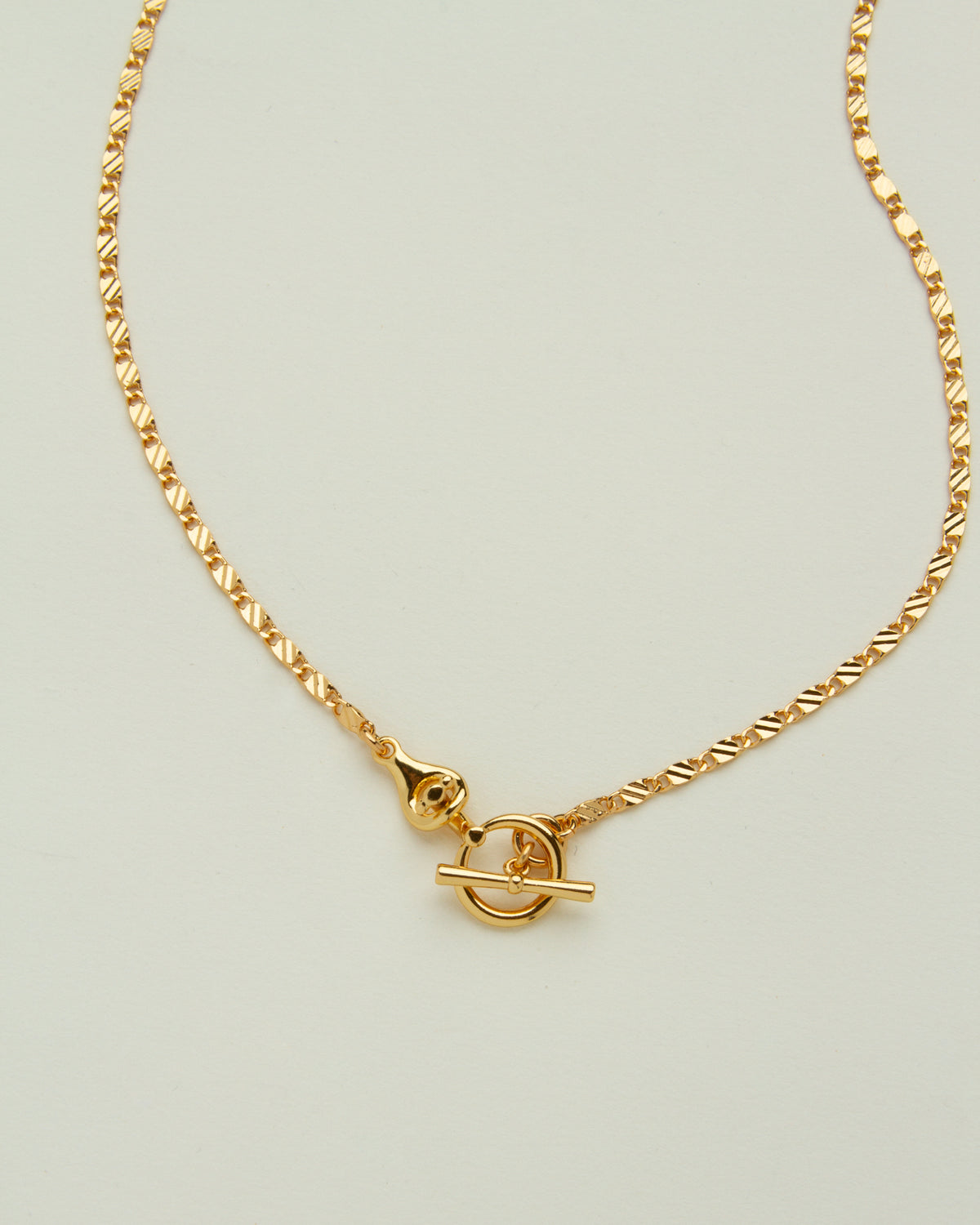Gold-plated Adorned Toggle Necklace with a unique clasp on a white background.