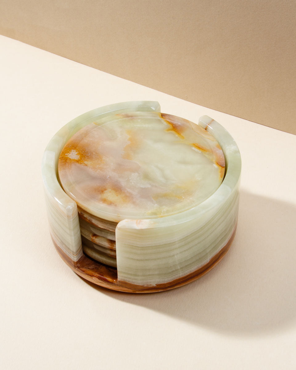 Stacked calcite stone coaster set with a cork bottom in a matching circular stone holder.