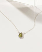 Silver plated necklace with a green gemstone pendant.